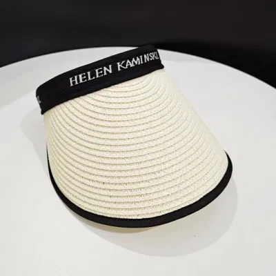 Sonnencreme und Sonnenschutz mit einem vielseitigen leeren Strohhut