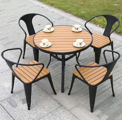Mesas de jardín de restaurante de madera plástica moderna y sillas al aire libre.