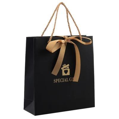 Bolsas de papel para compras personalizadas con asa de cinta de papel negro y lazo, con papel de tarjeta dorada para ropa interior, prendas de vestir, zapatos y ropa.